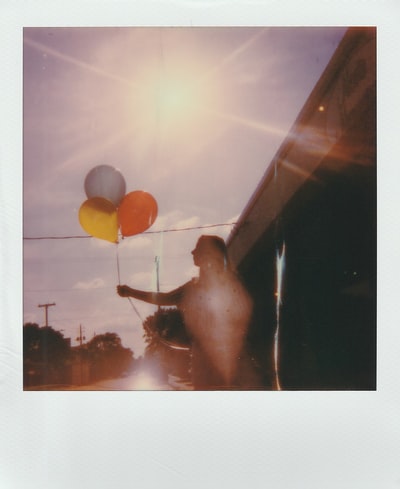 一名女子手持三个气球特写摄影